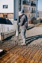 Mason building and worker using a automatic cement pump and levelling a layer of fresh concrete Royalty Free Stock Photo