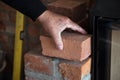 Mason checks a brick for a wall at the edge of the fireplace Royalty Free Stock Photo