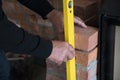 Mason checks a brick for a wall with a spirit level on a construction site