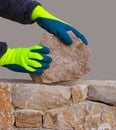 Mason hands working on masonry stone wall Royalty Free Stock Photo