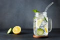 mason jar of cold detox water with cucumber and lemon on grey background