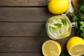 Mason jar of cold lemonade and ingredients on wooden table, flat lay. Space for text Royalty Free Stock Photo