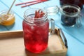 Mason jar of delicious iced hibiscus tea on light blue wooden table Royalty Free Stock Photo