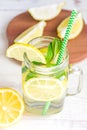 Mason jar glass of homemade lemonade with lemons, mint and green paper straw on wooden rustic background. Summer refreshing Royalty Free Stock Photo