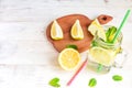 Mason jar glass of homemade lemonade with lemons, mint and green paper straw on wooden rustic background. Summer refreshing Royalty Free Stock Photo