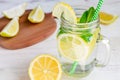 Mason jar glass of homemade lemonade with lemons, mint and green paper straw on wooden rustic background. Summer refreshing Royalty Free Stock Photo