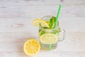 Mason jar glass of homemade lemonade with lemons, mint and green paper straw on wooden rustic background. Summer refreshing Royalty Free Stock Photo