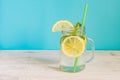 Mason jar glass of homemade lemonade with lemons, mint and paper straw on turquoise background. Summer refreshing beverage Royalty Free Stock Photo