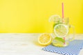 Mason jar glass of homemade lemonade with lemons, mint and red paper straw on wooden rustic background. Summer refreshing beverage Royalty Free Stock Photo