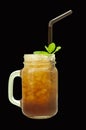 Mason jar glass of iced tea with straw isolated on a black background Royalty Free Stock Photo