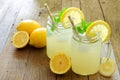 Mason jar glasses of homemade lemonade on rustic wood