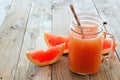 Mason jar of grapefruit juice on rustic wooden background Royalty Free Stock Photo