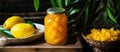 A mason jar of pickled peaches beside a bowl of lemons on a wooden table Royalty Free Stock Photo