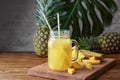 Mason jar with tasty fresh pineapple juice on wooden table Royalty Free Stock Photo
