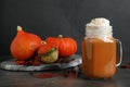 Mason jar with tasty pumpkin spice latte on table
