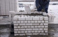Mason lays bricks set in cement, making the masonry walls,the construction of the house.