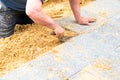 The mason lays gravel slabs on sand to make an alley