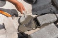 Mason lays out brickwork from gray bricks. Hands of builder with trowel close-up. Man works at construction site.