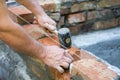 Mason making wall with mortar and bricks, using hammer tool. Industrial worker building exterior walls, using hammer for laying br Royalty Free Stock Photo