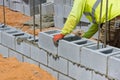 A mason is in the process of mounting a wall of aerated concrete blocks using masonry techniques