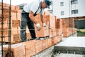 Mason using trowel, pan knife and mortar for brickwork, building outside walls