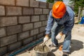 Masonry worker make concrete wall by cement block