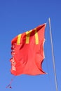 Red McDonalds flag against a clear blue sky.