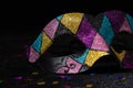 Masquerade mask with glitters and confetties on black background