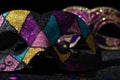 Masquerade mask with glitters and confetties on black background