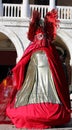 masquerade woman during the Venice carnival in Italy with long historical dress and the palace in the background