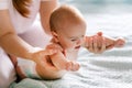 Massage for the baby. Four month old baby smiling doing gymnastics