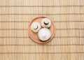 Massage bundles on a plate on a bamboo mat