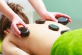 Massage with hot rocks stones in beautician Royalty Free Stock Photo