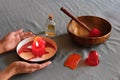 Massage items: oil, singing bowl, vacuum can on textile linen background. Female hands holding burning aroma candle Royalty Free Stock Photo