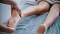 Massage - massage master is kneading womans feet with both hands Royalty Free Stock Photo