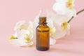 Massage oil. Orchid flower with natural oil in the Spa salon. Spa concept with white orchids on a pink background. Royalty Free Stock Photo