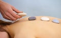 Massage procedure using round stones - Spa Royalty Free Stock Photo