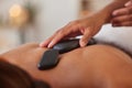 Massage with stone, hands and therapist in spa for wellness and peace, skincare and cosmetic luxury treatment. Holistic