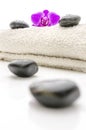 Massage stones and violet orchid flower on a towel Royalty Free Stock Photo