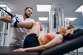 Massage and strength training of young woman legs and back on elastic machine to rehabilitate injury Royalty Free Stock Photo