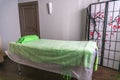 Massage table in the sauna green towel pillow curtain for changing clothes