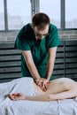 Massage therapist doing massotherapy of a young woman. Royalty Free Stock Photo