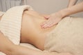 Massage therapist doing a thermic massage for the abdomen for a woman Royalty Free Stock Photo