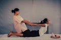 Massage Therapist giving Asian woman a Back Stretching in a Thai Massage Spa treatment Royalty Free Stock Photo