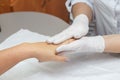 Massage therapist massaging hands of a woman in a beauty salon