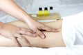 Massage therapist\'s hand massages young woman\'s calf muscles in spa salon.