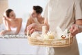 Massage therapist with spa essentials and young couple Royalty Free Stock Photo