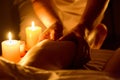 masseuse gives a man foot massage in a candlelit room Royalty Free Stock Photo
