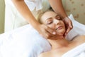 Massager massage around customerÃ¢â¬â¢s face for making beautiful woman relief from stress. Attractive beautiful girl feel relaxing a Royalty Free Stock Photo