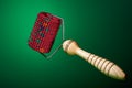 Massager with red drum, tree handle and metal needles on green background. is groundless. subject photo. For relaxation and health Royalty Free Stock Photo